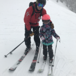 Dr. Carey skiing with his daughter. His kids frequently join him while ski patrolling, learning valuable lessons about the importance of service to others