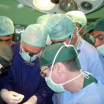 Dr. Carey operating on Iraqi soldier with Iraqi doctors observing.